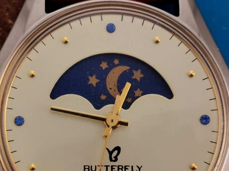Butterfly brand watch dial close up
